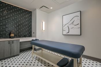 a massage table in a room with a sink and a painting at The Grand Central, Chicago, 60607